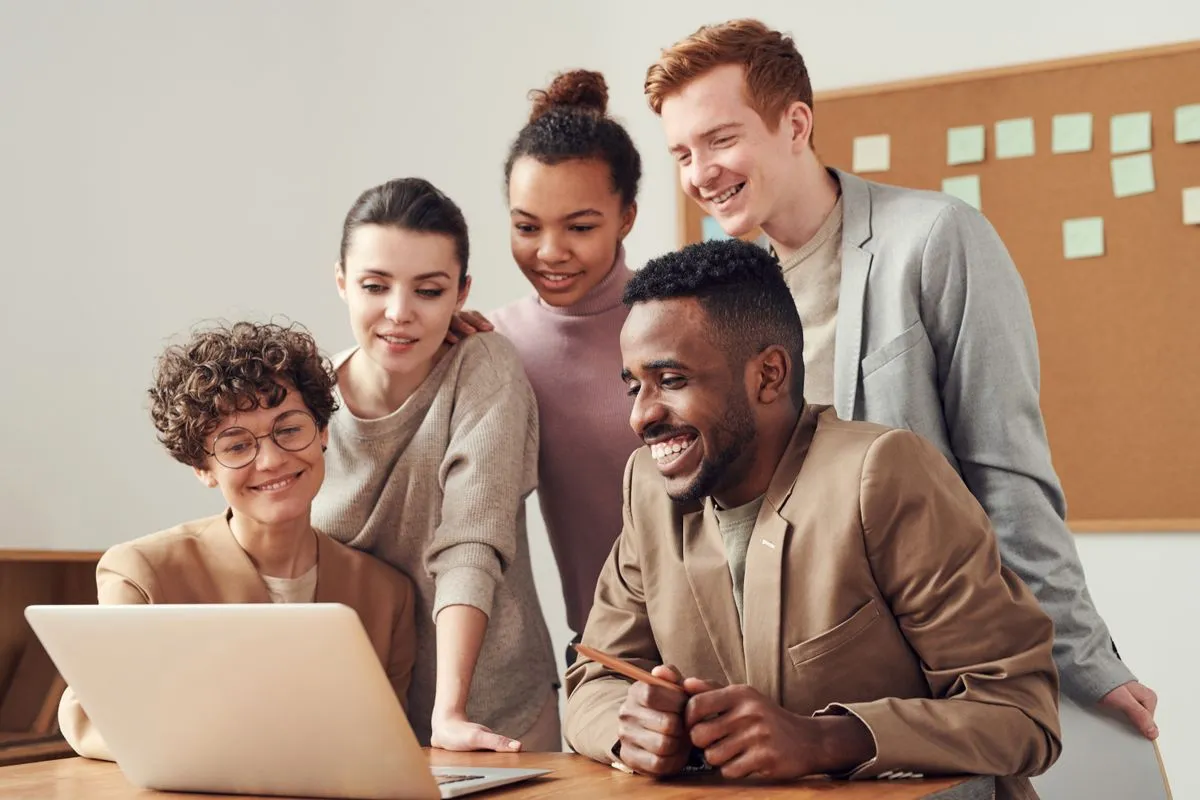A team collaborating around one laptop using the UPBIP workspace